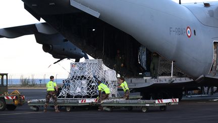 Des militaires français débarquent du matériel médical et d'urgence destiné à Mayotte, le 15 décembre 2024, à l'aéroport de Sainte-Marie (La Réunion). (RICHARD BOUHET / AFP)