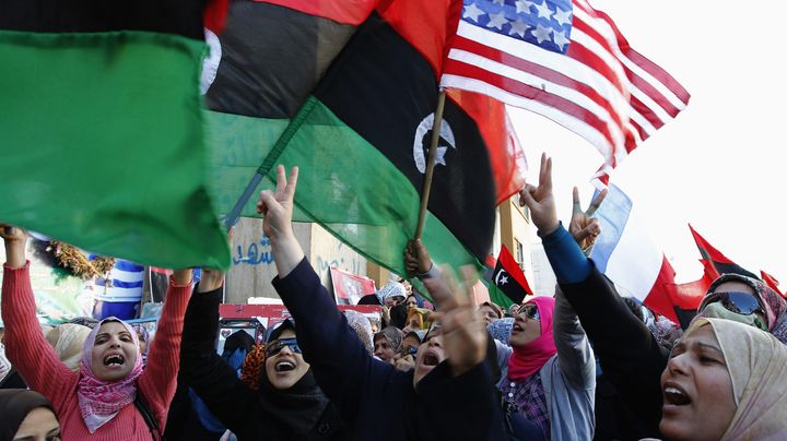 Des manifestants libyens brandissant c&ocirc;te &agrave; c&ocirc;te le nouveau drapeau de la Libye et celui des Etats-Unis, le 31 mars 2011 &agrave; Benghazi (Libye). ( YOUSSEF BOUDLAL / REUTERS)