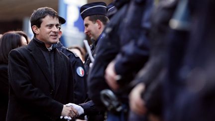 Le ministre de l'Int&eacute;rieur, Manuel Valls, salue des policiers &agrave; Paris, le 12 d&eacute;cembre 2012. (KENZO TRIBOUILLARD / AFP)