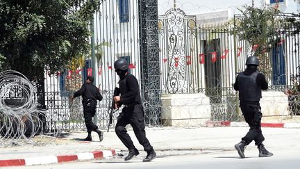 Les forces de s&eacute;curit&eacute; tunisiennes se d&eacute;ploient apr&egrave;s l'attaque men&eacute;e au mus&eacute;e du Bardo, le 18 mars 2015, &agrave; Tunis. Dix-neuf personnes, dont deux assaillants, sont mortes. (FETHI BELAID / AFP)