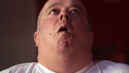 Un homme manque de s'&eacute;touffer lors du Wookey Hole Big Eat, une comp&eacute;tition dont le but est d'engouffrer le plus de tartes en 10 minutes, Wells (Royaume-Uni), le 22 novembre 2011. (MATT CARDY / GETTY IMAGES)