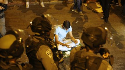 Les forces de sécurité israéliennes encadrent des prières de nuit, organisées en signe de protestation par les musulmans palestiniens devant l'entrée principale de la mosquée Al-Aqsa à Jérusalem, le 23 juillet 2017. (AHMAD GHARABLI / AFP)