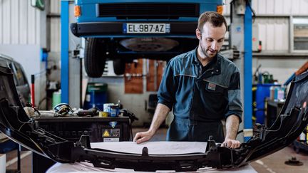 Benoît Villeneuve, le salarié du garage You, répare une voiture accidentée, le 21 mars 2022, aux Herbiers (Vendée). (PIERRE MOREL / FRANCEINFO)