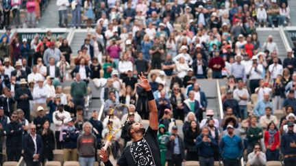 Le public est debout alors que Jo-Wilfried Tsonga joue l'un des derniers points de sa carrière, à la fin de son match de premier tour contre Casper Ruud, le 24 mai 2022, à Roland-Garros. (MINE KASAPOGLU / ANADOLU AGENCY / AFP)