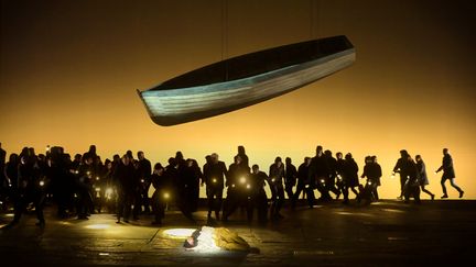 Le pêcheur Peter Grimes (Allan Clayton) est au sol, éclairé à la lanterne par les villageois (le chœur), dans  "Peter Grimes" de Benjamin Britten à l'Opéra Garnier. (VINCENT PONTET)