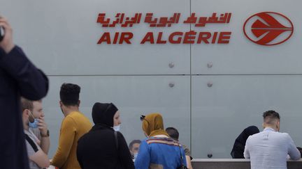 Des voyageurs attendent d'enregistrer pour un vol pour Paris au comptoir d'Air Algérie, à l'aéroport d'Alger, le 1er juin 2021. (- / AFP)