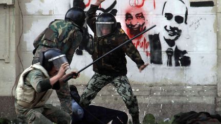 Des membres de l'arm&eacute;e &eacute;gyptienne passent &agrave; tabac une manifestante v&ecirc;tue d'un niqab, le 16 d&eacute;cembre au Caire. (AHMED ALI / AP / SIPA)