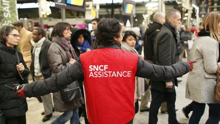 Une employée de la SNCF guide des voyageurs à la gare Saint-Lazare, à Paris, le 9 mars 2016 lors d'une précédente grève. (MATTHIEU ALEXANDRE / AFP)