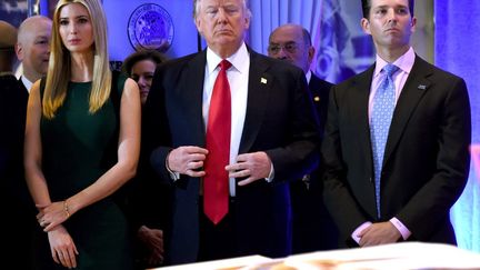 Donald Trump (au centre), flanqué de ses enfants Ivanka (à gauche) et Donald Jr. (à droite), le 11 janvier 2017 à la Trump Tower de New York (Etats-Unis). (TIMOTHY A. CLARY / AFP)