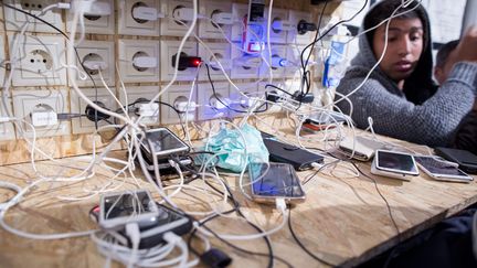 Plusieurs&nbsp;points d'électricté ont été installés dans le camp pour que les migrants puissent recharger leurs smartphones et garder contact avec leurs familles, le 5 mars 2016. (KAY NIETFELD / DPA)