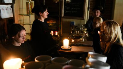 Des employés d'un café servent les clients à Lviv après des frappes russes sur des infrastructures électriques, le 11 octobre 2022. (YURIY DYACHYSHYN / AFP)