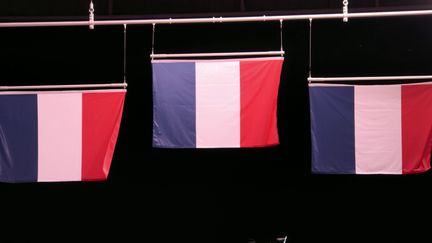 Les trois drapeaux tricolores français flottent au-dessus du site de Saint-Quentin-en-Yvelines, le 2 août 2024, après la course de BMX. Joris Daudet, Sylvain André et Romain Mahieu sont montés sur le podium olympique. (France Télévisions)