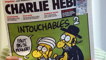 Un homme regarde les caricatures du proph&egrave;te Mahomet parues dans le num&eacute;ro de "Charlie Hebdo" dat&eacute; du 19 septembre 2012, &agrave; Paris. (THOMAS COEX / AFP)