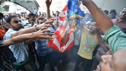 Des Egyptiens protestent devant l'ambassade am&eacute;ricaine au Caire (Egypte) en br&ucirc;lant un drapeau des Etats-Unis, le 12 septembre 2012. (KHALED DESOUKI / AFP)