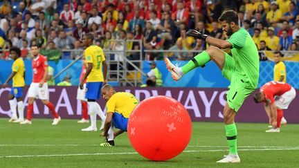 L'intrus. Le gardien du Brésil Alisson éclate un ballon de baudruche lors du match de poules contre la Suisse (1-1), le 17 juin 2018 à Rostov en Russie. (PASCAL GUYOT / AFP)