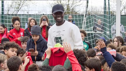 Sadio Mané, owner of FC Bourges 18, alongside young players from the club, March 16, 2024, at the Jacques Raimbault stadium. (GUILLAUME SOUVANT / AFP)