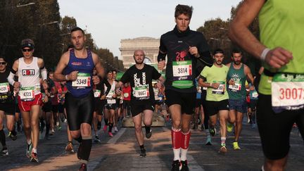 Les coureurs s'élancent sur les Champs-Élysées, le 17 octobre 2021. (GEOFFROY VAN DER HASSELT / AFP)