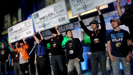 De gauche &agrave; droite, les joueurs "GamaniaSen", "Nestea", et "MVP", brandissent leurs ch&egrave;ques de r&eacute;compense apr&egrave;s la finale de la comp&eacute;tition Global Starcraft II, organis&eacute;e le 22 octobre 2011 &agrave; Anaheim (Californie). (DEREK BAUER / AP / SIPA)