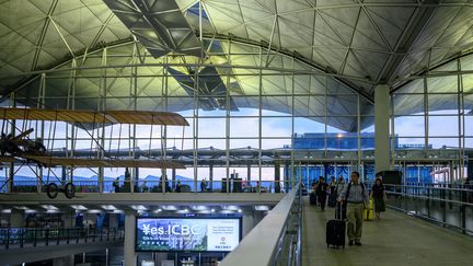 Des passagers arrivent à l'aéroport de Hong Kong, le 14 août 2019. (PHILIP FONG / AFP)