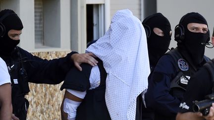 Des policiers escortent Yassin Salhi, le 28 juin 2015, &agrave; Saint-Priest (Rh&ocirc;ne). (PHILIPPE DESMAZES / AFP)