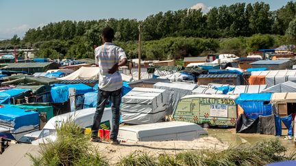 Un migrants devant le camp de Calais surnommé "la Jungle", le 24 juin 2016. (PHILIPPE HUGUEN / AFP)