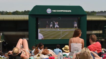 Lors de la journ&eacute;e la plus chaude de l'ann&eacute;e en Grande-Bretagne, le 1er juillet 2015, les fans de tennis suivent les matchs de Wimbledon sous le soleil.&nbsp; (KARWAI TANG / WIREIMAGE / GETTY IMAGES )