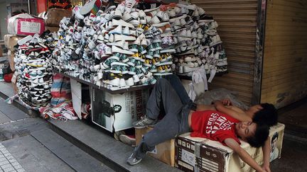 pour ces travailleurs migrants qui proposent des chaussures bon marché dans une rue de Shenzhen, au Guangdong.
 
 

  (Yu Haibo)