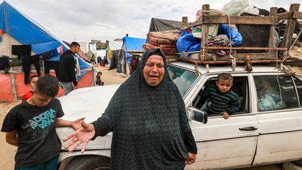 A woman and children flee Rafah, February 13, 2024. (MOHAMMED ABED / AFP)