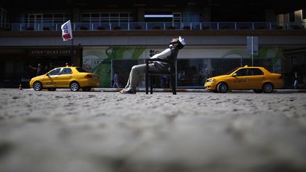 Un manifestant portant un masque de Guy Fawkes se repose place Taksim &agrave; Istanbul (Turquie), le 3 juin 2013. (STOYAN NENOV / REUTERS)