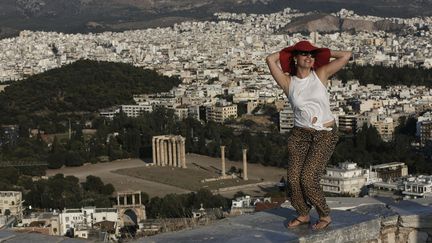 Une touriste pose sur la colline de l'Acropole &agrave; Ath&egrave;nes (Gr&egrave;ce), le 4 juillet 2013. (JOHN KOLESIDIS / REUTERS)