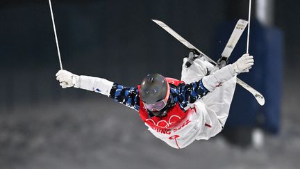 Le Français Benjamin Cavet réalise un back cross lors de son run en qualifications du ski de bosses aux JO 2022, jeudi 3 février 2022. (BEN STANSALL / AFP)