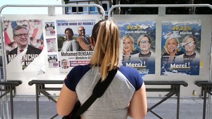 Une femme se tient devant des panneaux de l'entre-deux-tours des élections législatives, le 16 juin 2022, à Marseille (Bouches-du-Rhône). (MAXPPP)