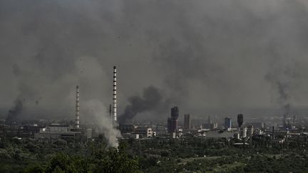 De la fumée s'élève au-dessus de&nbsp;Sievierodonetsk (est de l'Ukraine), le 14 juin 2022. (ARIS MESSINIS / AFP)