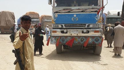 Des agents de sécurité en civil montent la garde alors que des camions de marchandises se préparent à se diriger vers le poste frontière afghan de Chaman, après la réouverture partielle d'un point de passage clé entre le Pakistan et l'Afghanistan, quelques jours après que les talibans ont pris le contrôle de la ville frontalière afghane dans le cadre d'une offensive rapide à travers le pays.&nbsp; (ASGHAR ACHAKZAI / AFP)