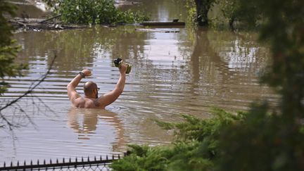 Un homme s'aventurant dans l'eau après les inondations à Opava (République tchèque) se retrouve avec de l'eau jusqu'à la poitrine, le 15 septembre 2024. (JAROSLAV OZANA / AP / SIPA)