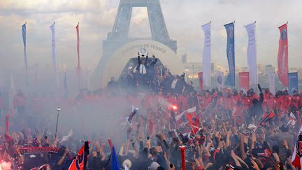 Les joueurs du Paris Saint-Germain c&eacute;l&egrave;brent leur titre de champion de France en compagnie de de leurs supporters devant la tour Eiffel &agrave; Paris, le 13 mai 2013. (FRANCK FIFE / AFP)