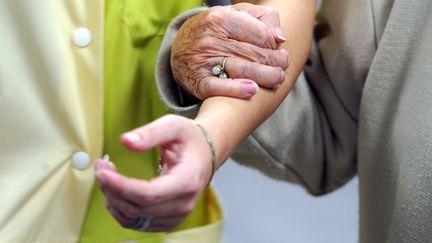 Illustration d'une aide&nbsp;soignante accompagnant une personne âgée. (JEAN-FRANCOIS MONIER / AFP)