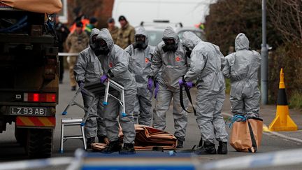 Des militaires britanniques examinent une voiture liée à l'empoisonnement de l'ex-espion russe Sergueï Skripal et et sa fille Yulia Skripal, le 14 mars 2018. (ADRIAN DENNIS / AFP)