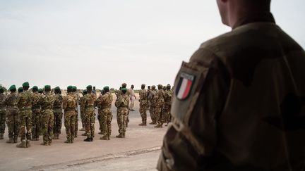 Un soldat français regarde une unité malienne arriver à l'aéroport de Tombouctou, le 14 décembre 2021. (FLORENT VERGNES / AFP)