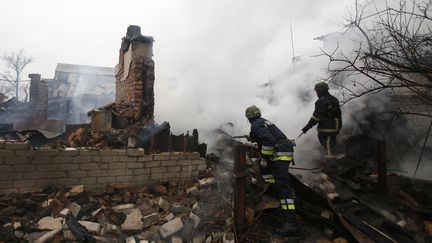 Des pompiers ukrainiens interviennent dans un immeuble touché par des tirs d'artillerie des rebelles pro-russes, le 25 février 2017 à Avdiivka (Ukraine). (ANATOLII STEPANOV / AFP)