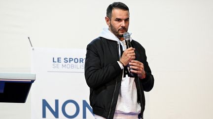 L'athlète français Mehdi Baala à la tribune d'un rassemblement de sportifs pour lutter contre l'extrême droite à l'Institut de judo de Paris, le 19 avril 2022. (BERTRAND GUAY / AFP)