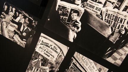 Des photos d'Américains lisant le journal après l'assassinat du président&nbsp;John F. Kennedy, lors d'une exposition en novembre 2013 à Washington (Etats-Unis). (BRENDAN SMIALOWSKI / AFP)