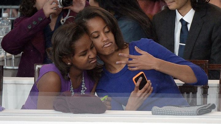 Sasha (&agrave; gauche) et Malia Obama posent pour un "selfie" durant la c&eacute;r&eacute;monie d'investiture de leur p&egrave;re, le 21 janvier 2013 &agrave; Washington (DC). (JOE KLAMAR / AFP)