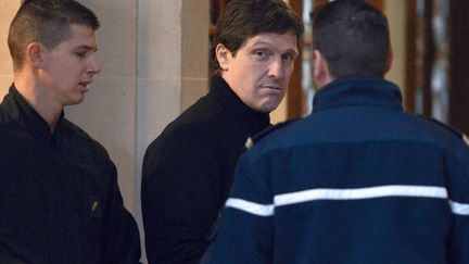 Fran&ccedil;ois-Marie Giacobetti (au centre), escort&eacute; par la police, lors de son arriv&eacute;e au tribunal correctionnel de Paris, le 5 d&eacute;cembre 2012, le premier jour du proc&egrave;s de l'affaire du Cercle Wagram. (MIGUEL MEDINA / AFP)