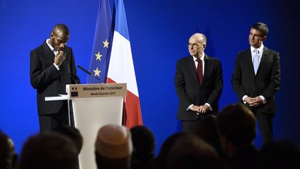 Lassana Bathily durant la c&eacute;r&eacute;monie de naturalisation, mardi 20 janvier,&nbsp;au minist&egrave;re de l'Int&eacute;rieur, en pr&eacute;sence de Bernard Cazeneuve et Manuel Valls.&nbsp; (ERIC FEFERBERG / AFP)