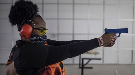 Une femme participe&nbsp;à un stage "Girl on Fire" pour apprendre à se servir d'une arme à feu, à&nbsp;Midrand, en Afrique du Sud, le 7 février 2021. (MARCO LONGARI / AFP)