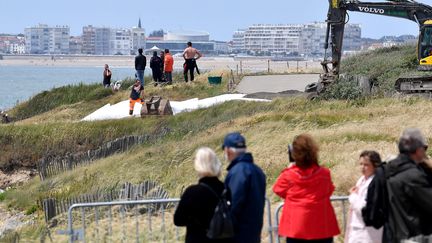 Derrière les barrières qui empêchent l'accès au lieu de l'accident du bateau de la SNSM, des habitants sont venus se recueillir, samedi 8 juin 2019. (JOEL LE GALL / MAXPPP)