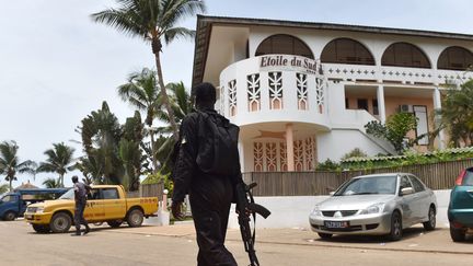 Un soldat ivoirien passe devant l'hôtel Etoile du Sud, le 14 Mars 2016 à Grand Bassam (Cote-d'Ivoire) un jour après l'attaque de la&nbsp;station balnéaire. (ISSOUF SANOGO / AFP)