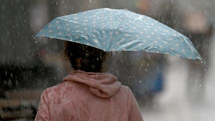 A passerby protects herself from the rain, October 28, 2021, in Montpellier (Hérault).  (PASCAL GUYOT / AFP)