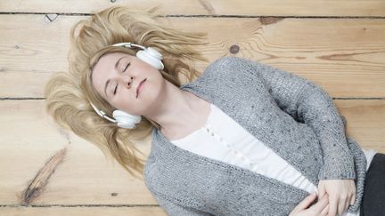 Une jeune femme écoute de la musique au casque. (ULLSTEIN BILD DTL. / GETTY IMAGES)